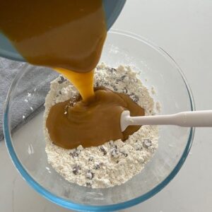 Pouring the wet ingredients into the dry ingredients.