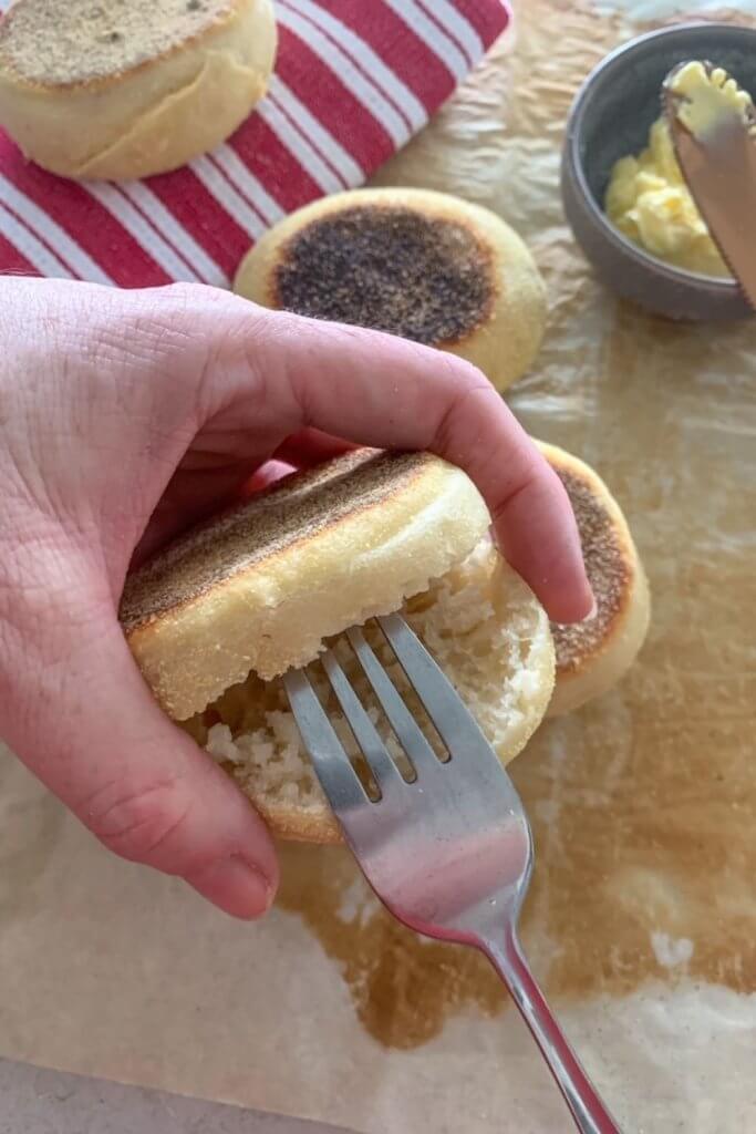 Fork splitting a sourdough English Muffin