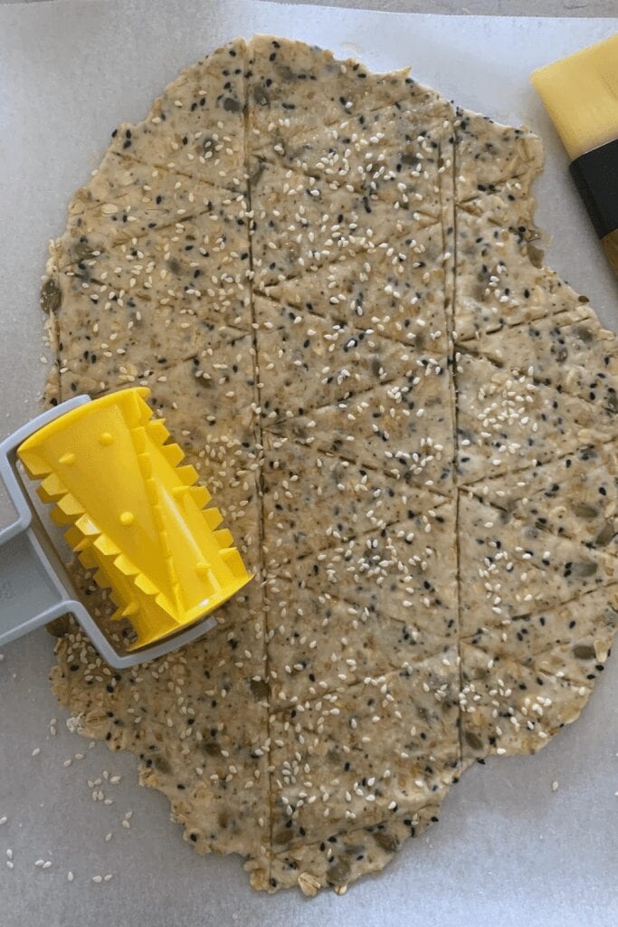 Seedy sourdough discard crackers - cracker cutting tool making it easier to score the crackers.