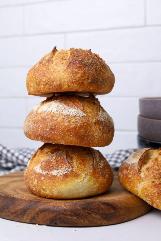 3 sourdough boules stacked on top of each other, each with a bubbly, caramelised crust as a result of using diastatic malt powder.