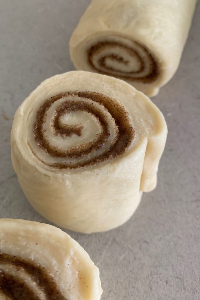 Fluffy sourdough cinnamon rolls that have been perfectly cut using dental floss so that the dough isn't squashed.