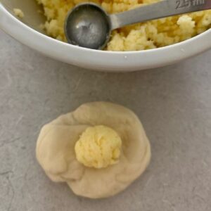 Add a small ball of garlic butter & cheese to each piece of dough