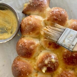 Brushing cooked sourdough Christmas Tree bread with garlic butter
