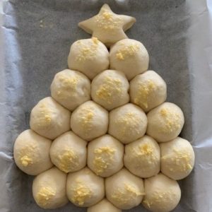Puffy sourdough Christmas Tree brushed with garlic butter ready to go into the oven