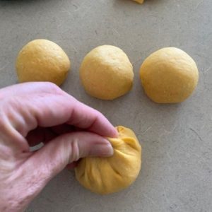 rolling pumpkin sourdough dinner rolls into balls