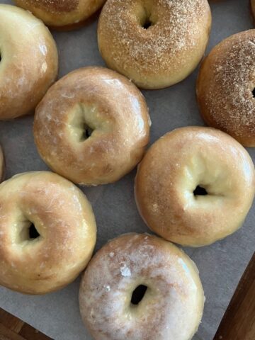 Baked sourdough donuts displayed on a wooden tray