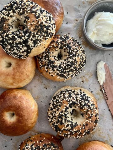 Easy sourdough bagels on tray with cream cheese