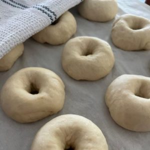 Cover formed bagels with a cloth and allow them to get puffy