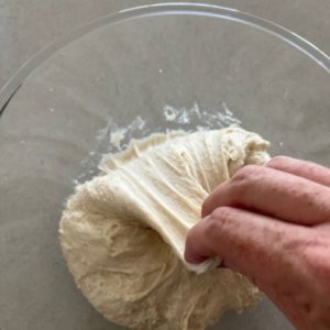 Complete a series of stretches and folds around the bowl to bring the dough into a ball.
