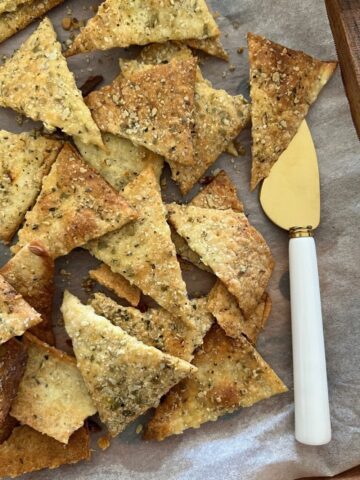 Savory Sourdough Vegan Crackers displayed on a tray with a palette knife.