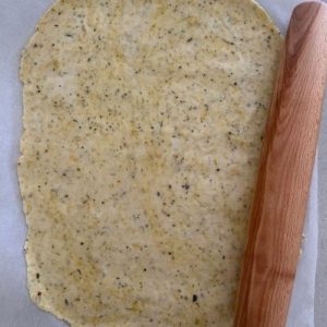 Sourdough vegan crackers dough rolled out super thin using rolling pin.