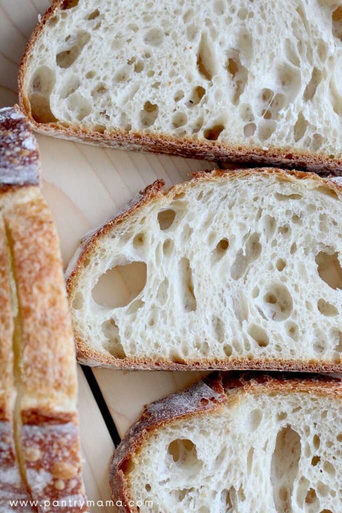 Photo shows 3 slices of open crumb sourdough bread.