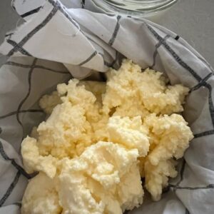 Cultured butter tipped into a thin piece of cloth ready to strain out all the butermilk.