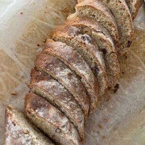 Sourdough biscotti logs being sliced into 1 cm pieces