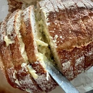 Using a butter knife, spread the garlic butter onto the sourdough slices, being generous with the butter.