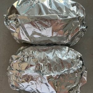 2 loaves of sourdough garlic bread wrapped in aluminium foil