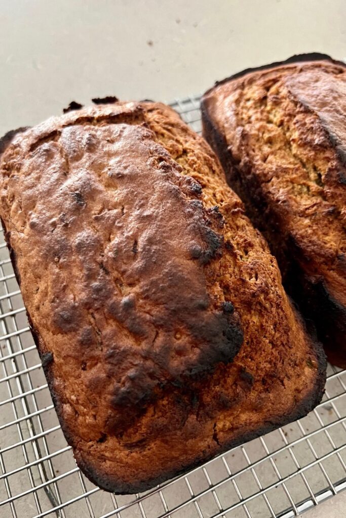 Easy sourdough zucchini bread - 2 loaves of sourdough zucchini bread sitting on a cooling rack