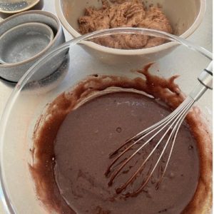 Whisking the sourdough chocolate cake batter with vegetable oil, cocoa, baking soda, baking powder and salt.