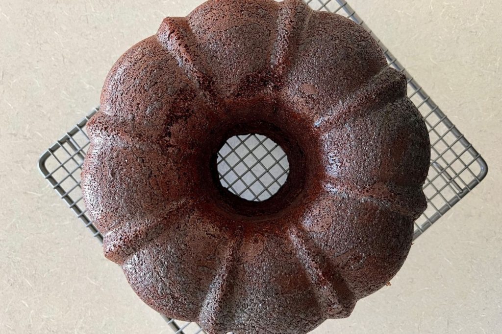 sourdough discard chocolate cake made in a bundt pan sitting on a wire cooling rack.