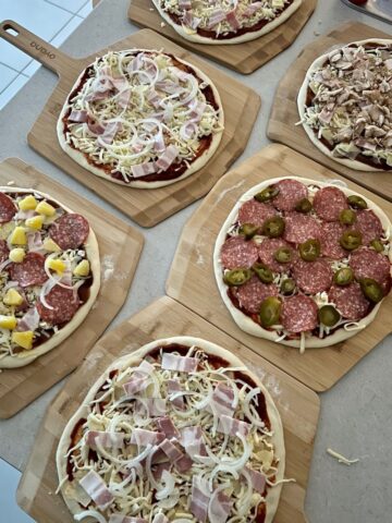 Best pizza toppings for homemade pizza - this photo shows 6 homemade pizzas all with different toppings.