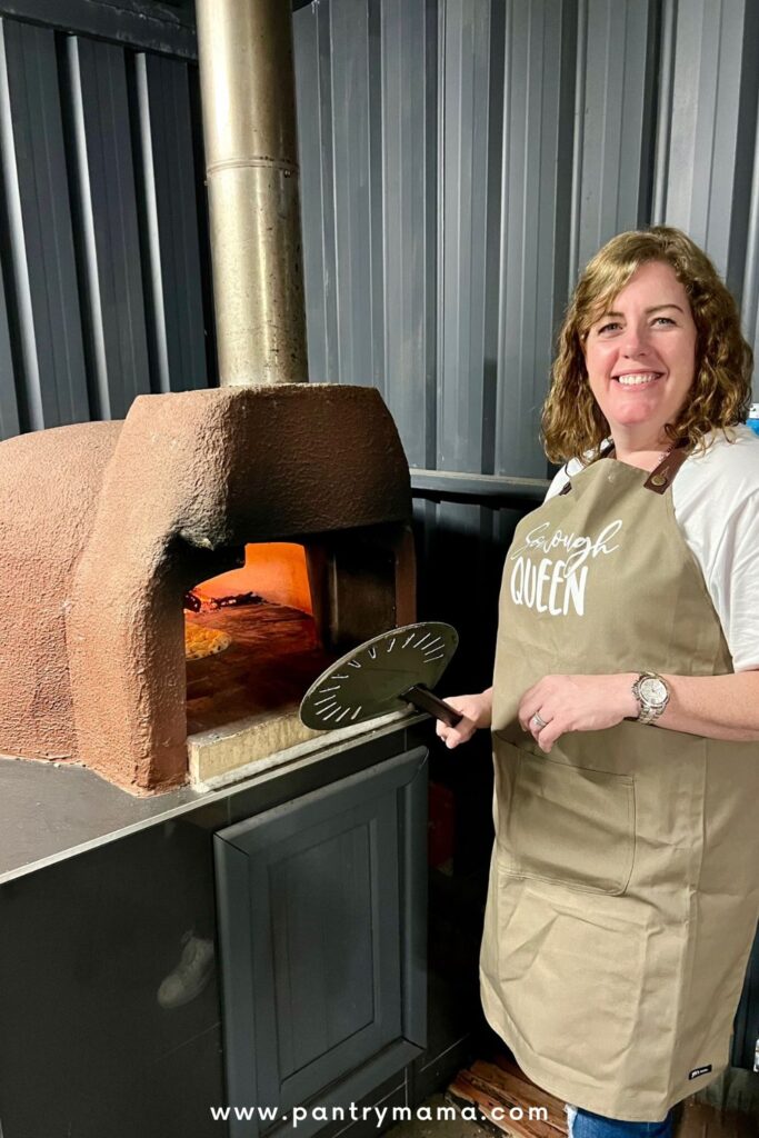 Cooking homemade pizza toppings in an outdoor woodfired pizza oven.