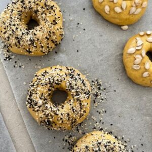 Sourdough pumpkin bagels dipped in Everything But The Bagel Seasoning