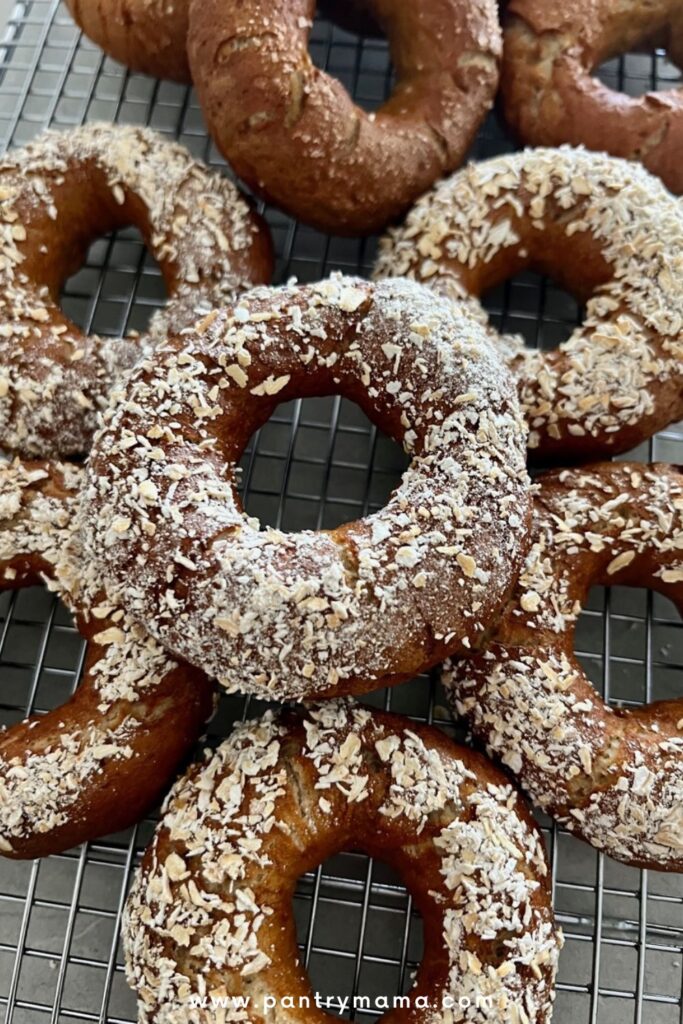 A pile of sourdough rye bagels topped with ground oats.