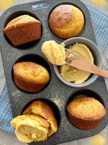 Sourdough Cornbread Muffins sitting in a muffin tray and served with whipped honey cinnamon butter