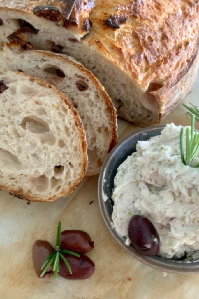 Creamy olive dip served with a loaf of olive sourdough bread.