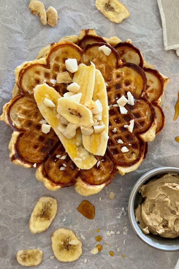 SOURDOUGH BANANA WAFFLES served with banana slices, whipped honey cinnamon butter and crushed macadamia nuts.