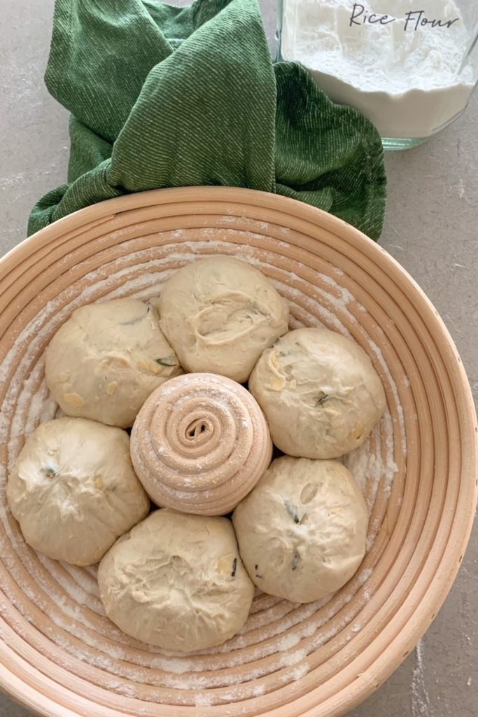 Stop sourdough sticking to bannetons by using rice flour. This photo shows 6 balls of dough sitting in a round banneton dusted with rice flour.