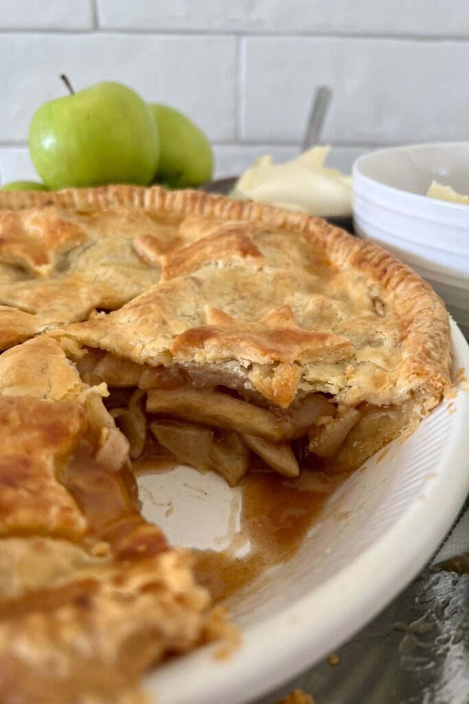 Sourdough apple pie that has been cooled and a slice cut out to show that the sauce is thicker if you leave the pie to cool for a sufficient amount of time.