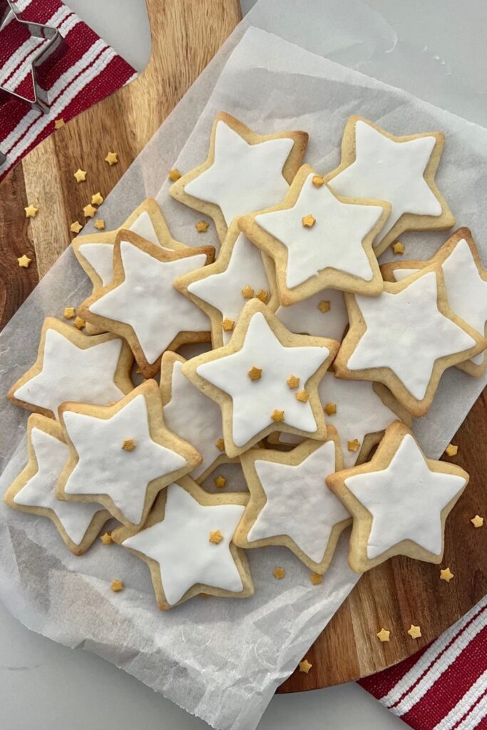 Sourdough sugar cookies decorated with white fondant stars and sprinkled with gold star sprinkles.