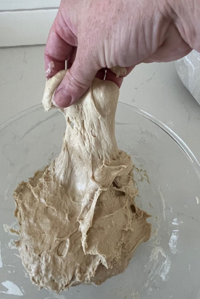 Forming rye sourdough into a ball using small stretch and folds around the bowl.