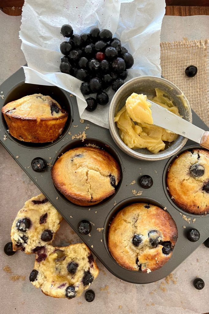 How to add sourdough starter to any recipe - sourdough blueberry muffins sitting in a 6 hole muffin tray.