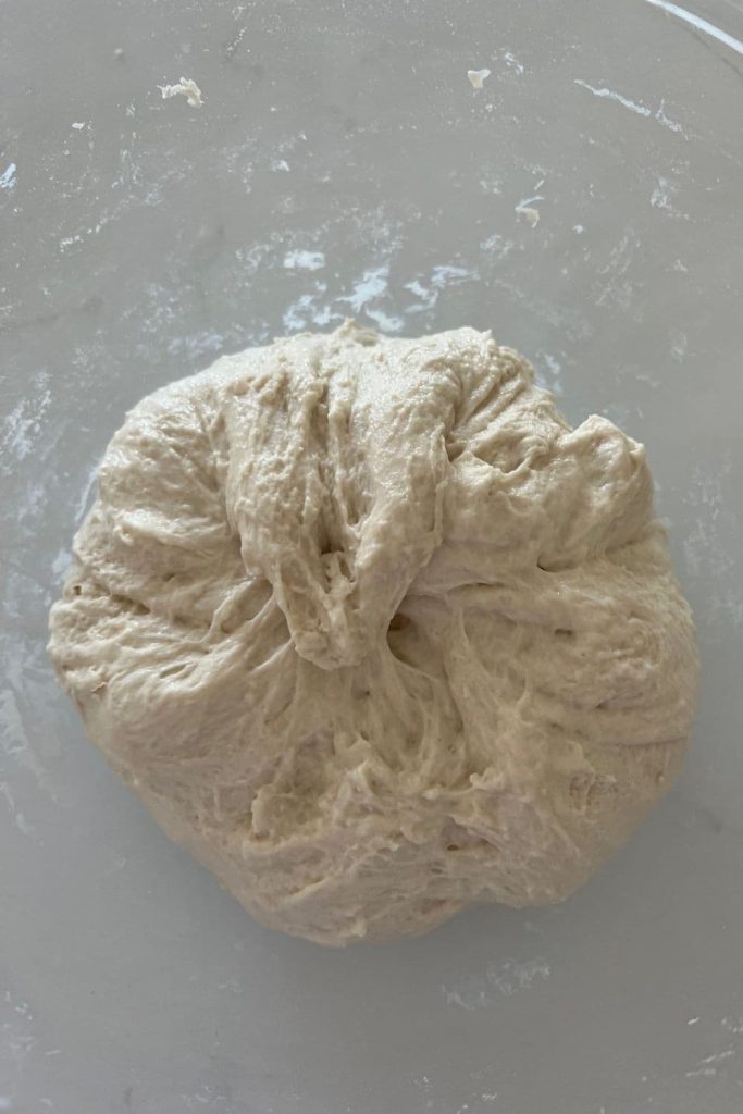 A ball of overnight sourdough bread that has been formed up where the shaggy dough has been pulled into a ball.