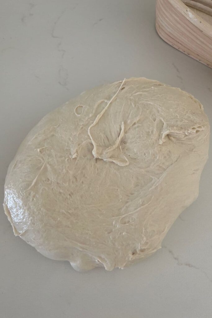 Sourdough that has been flipped onto the counter with the sticky side up.