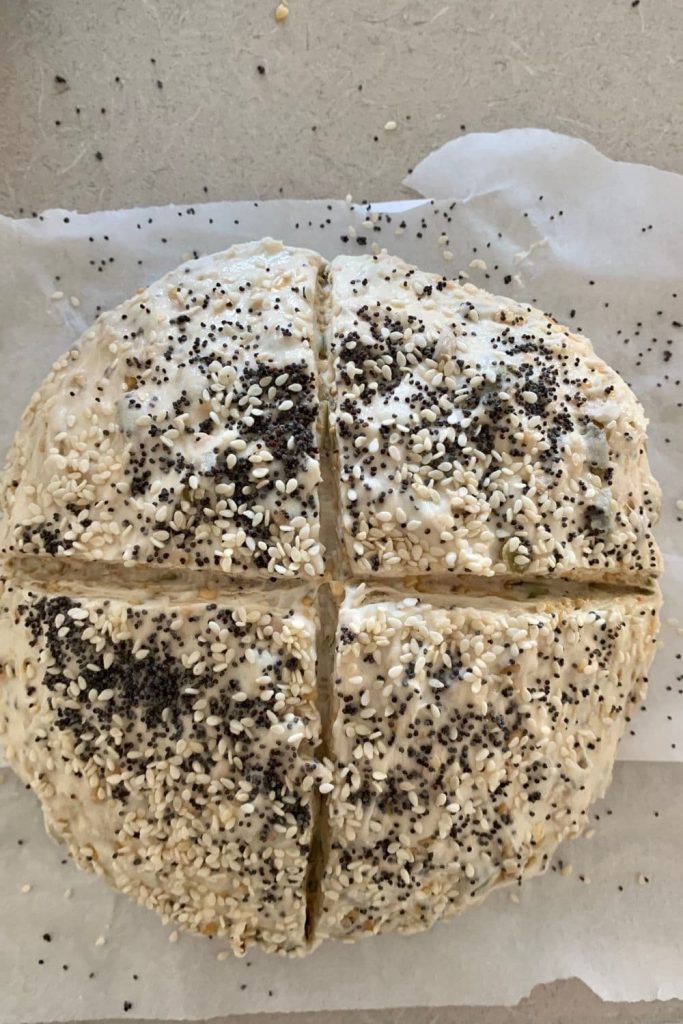Multigrain sourdough loaf that has been shaped and scored. It has been topped with poppy seeds and is waiting to be placed into a hot Dutch oven.