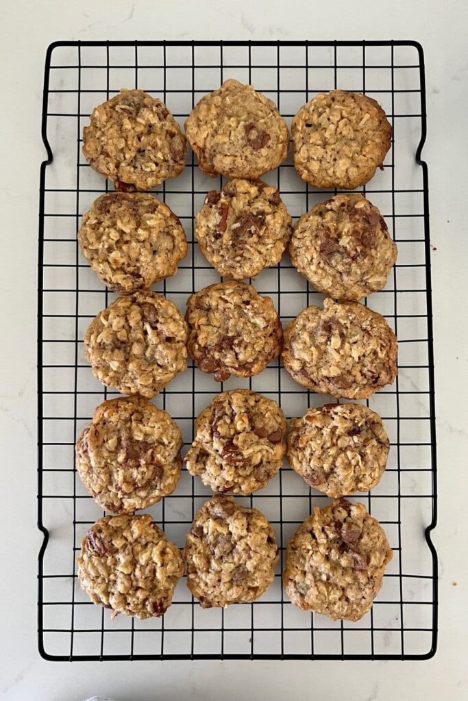 Black wire cooling rack with 12 sourdough discard cowboy cookies sitting on it.