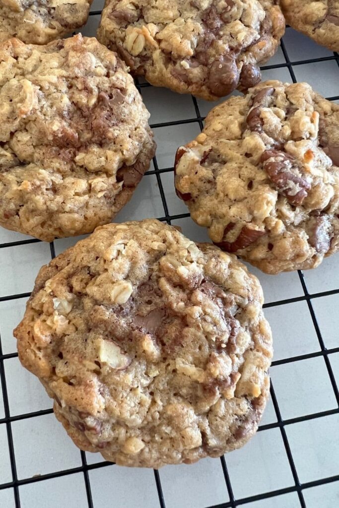 sourdough cowboy cookies cooling on a black wire rack.