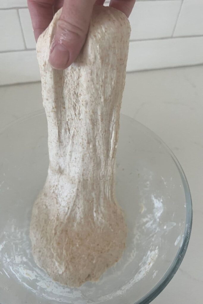 Spelt sourdough that is being stretched and folded. The dough is stretchy and elastic.