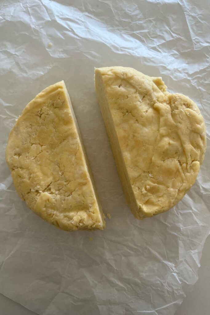 A large disc of sourdough pie crust that has been cut into two pieces.