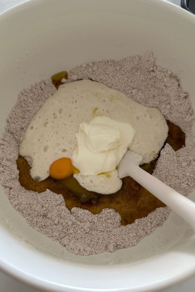 All of the dry ingredients mixed in a bowl, with a well in the centre to add the wet ingredients for this sourdough applesauce cake.