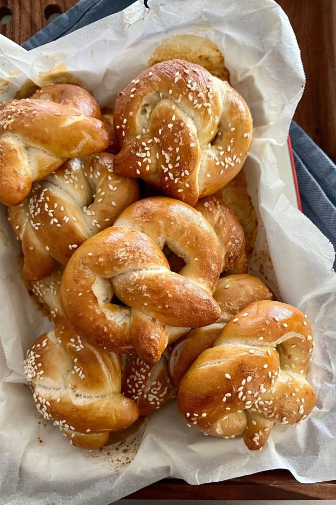 Tray of sourdough pretzels topped with sesame seeds.