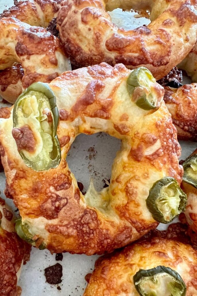 Sourdough bagels topped with jalapenos and cheddar cheese.