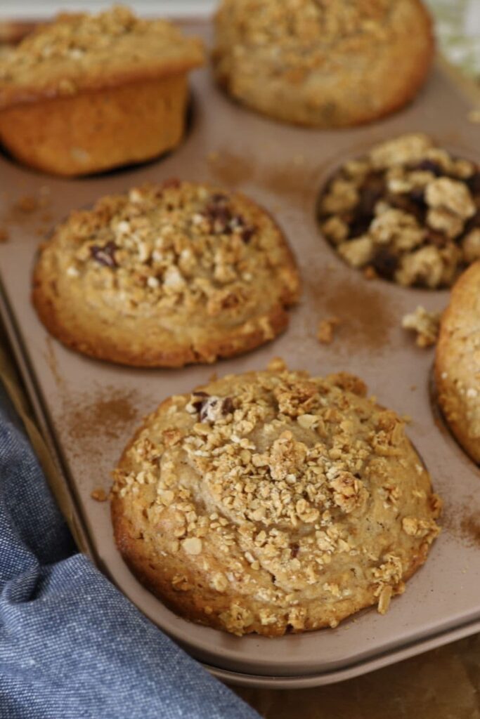 JUMBO SOURDOUGH GRANOLA MUFFINS - FEATURE IMAGE
Sourdough Granola Muffins are sitting in a giant 6 hole muffin tin with a blue dish towel in the foreground.