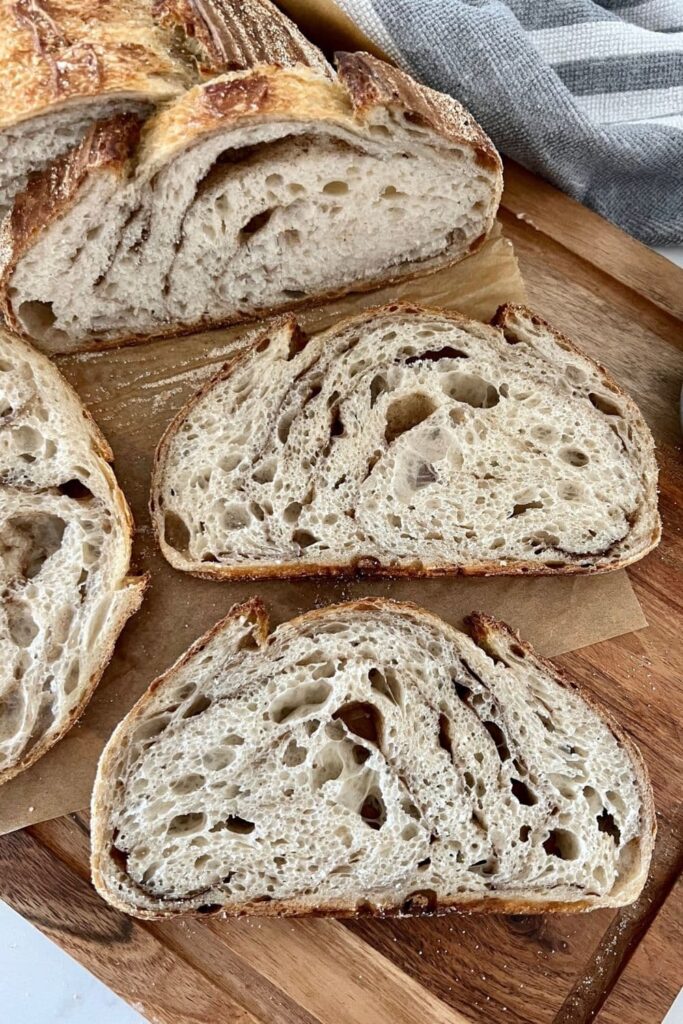 2 slices of sourdough cinnamon swirl bread sitting on a wooden board.