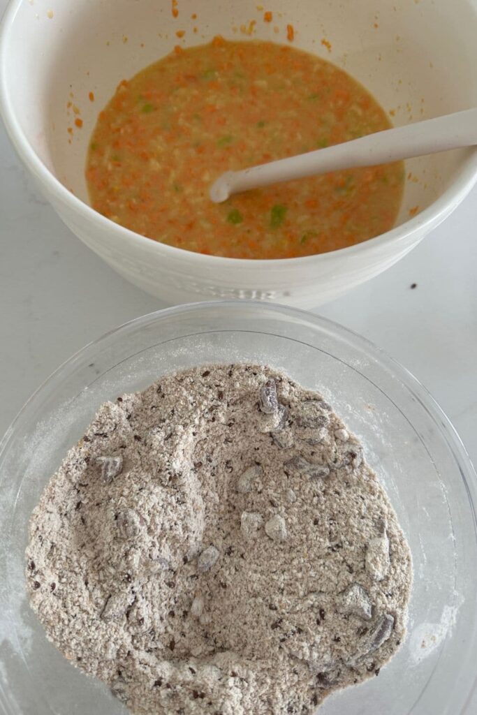 A bowl of wet ingredients and a bowl of dry ingredients ready to be mixed together to make Sourdough Morning Glory Muffins.