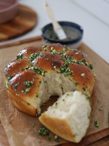 Sourdough Pampushky or Ukrainian Garlic Bread that has been taken out of the tin and broken apart so you can see the super fluffy texture inside the bread rolls.