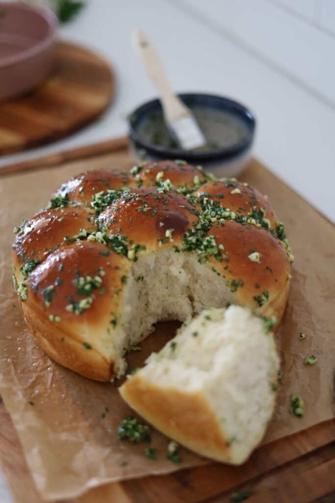 Sourdough Pampushky or Ukrainian Garlic Bread that has been taken out of the tin and broken apart so you can see the super fluffy texture inside the bread rolls.